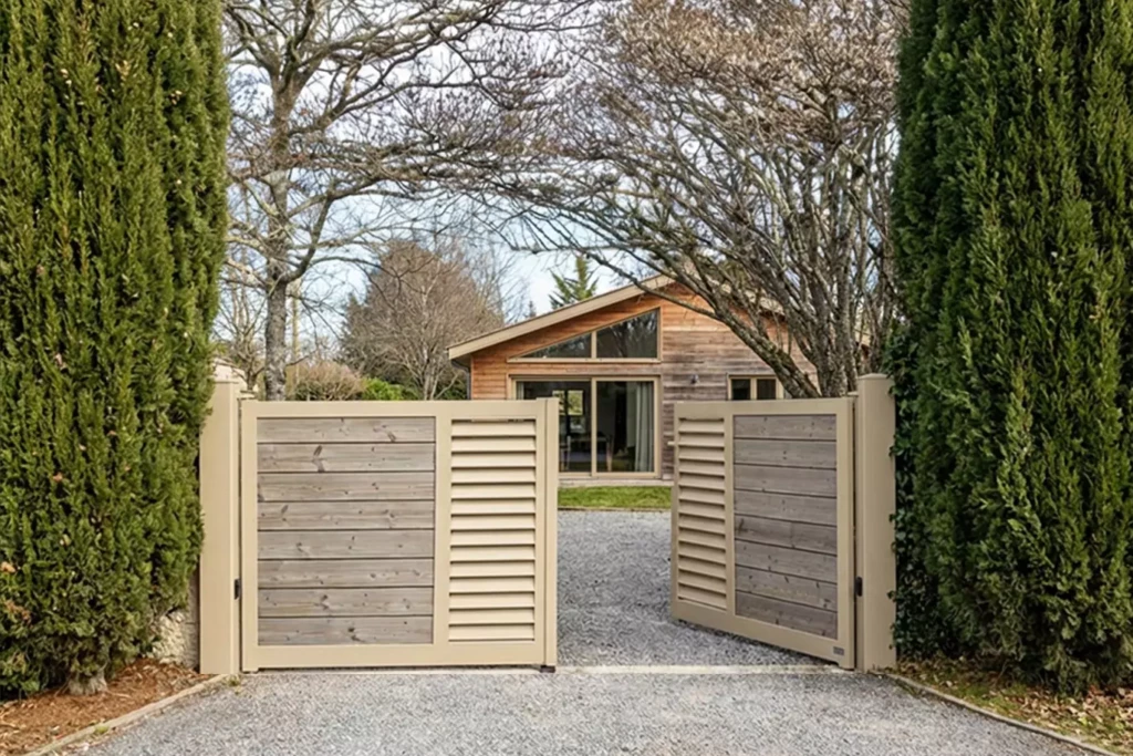 Portail aluminium FANGO deux battants avec cadre beige, lattes aluminium biais centrales et remplissage bois en pin thermotraité, installation sur mesure