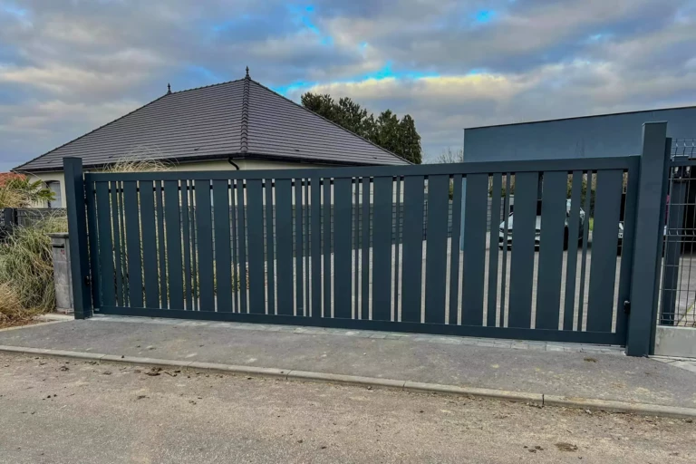 Portail DURANCE aluminium coulissant avec lattes verticales ajourées de largeurs variables, design contemporain laissant passer la lumière