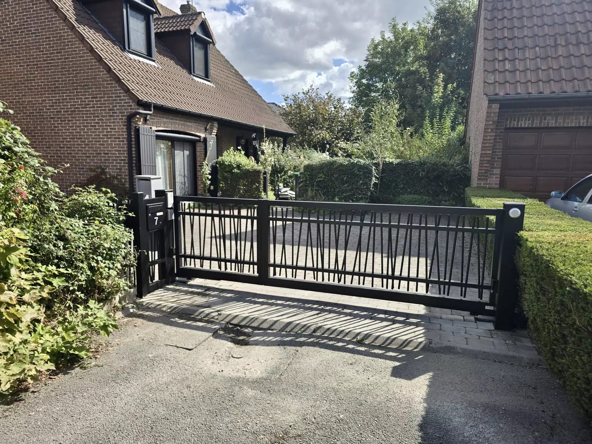 Portail aluminium sur mesure Beaumont à ouverture tiercée avec vantaux inégaux et clôture assortie