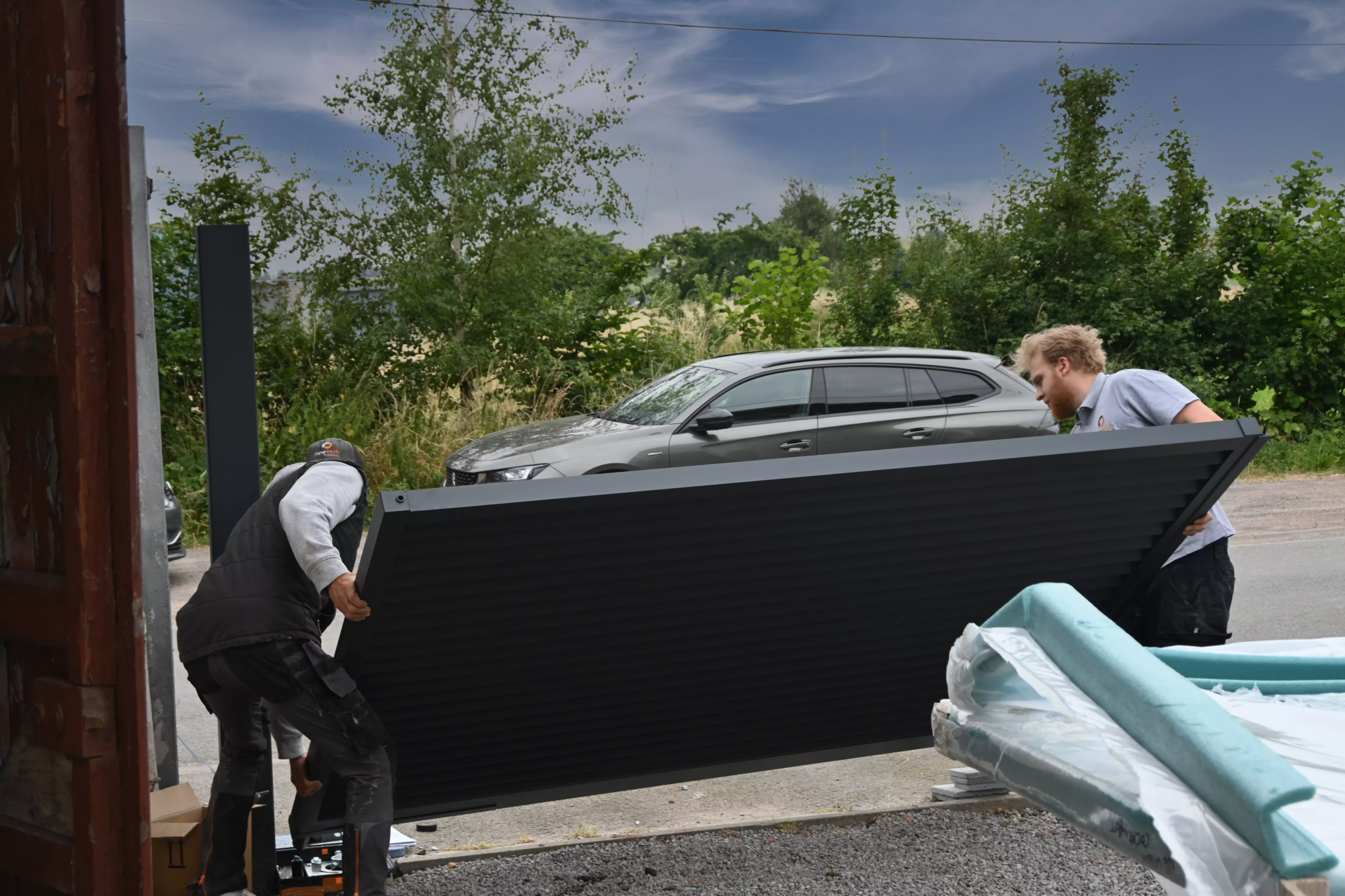 Installateur partenaire Eurofactory posant un portail aluminium sur mesure chez un particulier