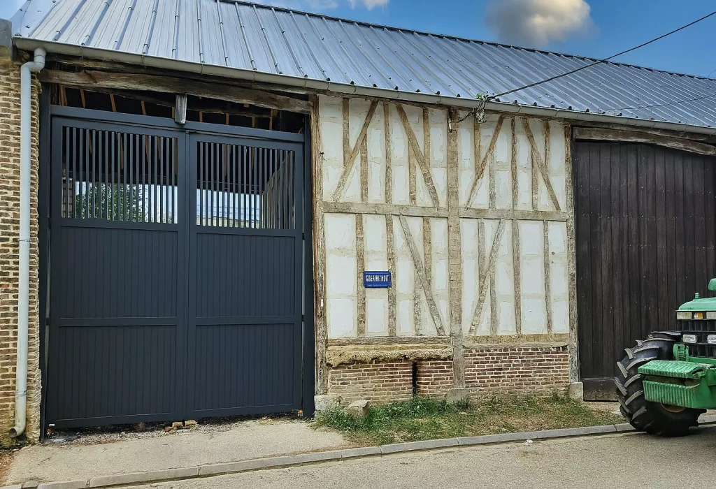Porte cochère aluminium semi-ajourée sur-mesure installée sur un corps de ferme, création EUROFACTORY, fabrication française garantie 10 ans